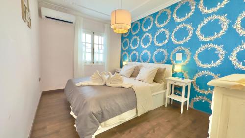 a bedroom with a bed with a blue wall at Exclusive Villa Valencia - Denia Els Poblets in Els Poblets