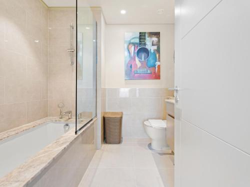 y baño con bañera y aseo. en Sophisticated and Trendy 2BDR In Forte Downtown en Dubái