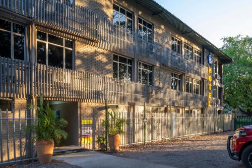 a brick building with two potted plants in front of it at N1 Hotel & Campsite Victoria Falls in Victoria Falls