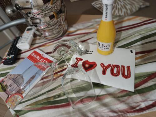 ein Tisch mit einer Flasche und ein Liebesbrief darauf in der Unterkunft Casa vacanza Regina in Barletta