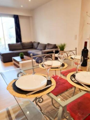 - un salon avec deux tables et des verres à vin dans l'établissement Appartement Nice avec balcon et parking privé, à Nice