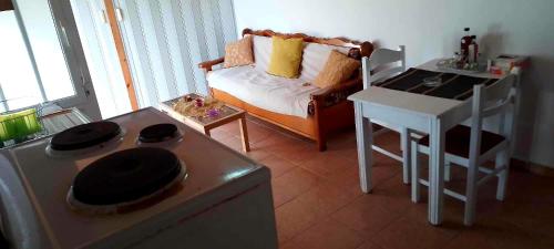 a living room with a kitchen with a stove and a table at Despina's House in Sitia