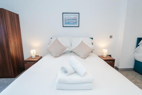 George House Modern Apartments by VICHY في هال: غرفة نوم بسرير ابيض مع مواقف ليلتين