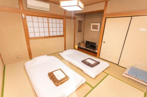 a small room with two beds in it at ゲストハウスOneWorld Toji東寺 in Kyoto
