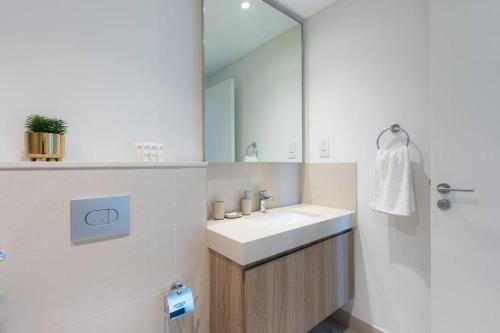 a bathroom with a sink and a mirror at Sunny Downtown Retreat- Direct access to Dubai Mall in Dubai