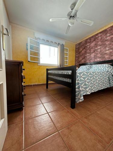 a bedroom with a bed and a brick wall at Abades Chalet in Abades