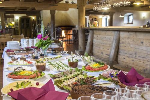 una mesa con muchos platos de comida. en Pałac Galiny en Bartoszyce- Galiny