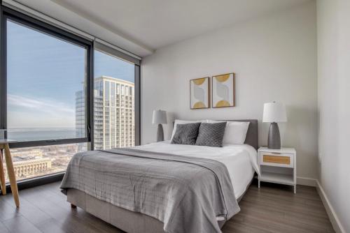 a bedroom with a large bed and a large window at Blueground South Loop pool sports nr park CHI-1042 in Chicago