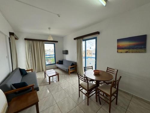 a living room with a table and a couch at Kefalonitis Hotel Apartments in Paphos