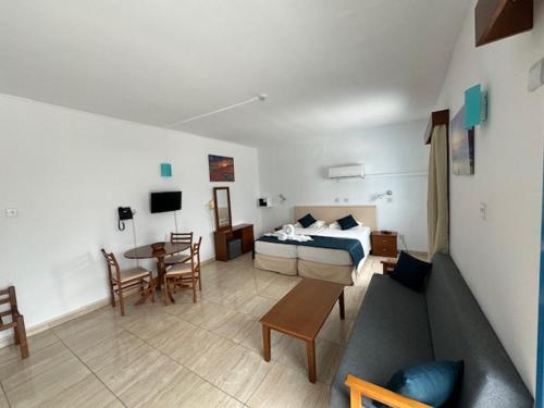 a living room with a bed and a couch and a table at Kefalonitis Hotel Apartments in Paphos City