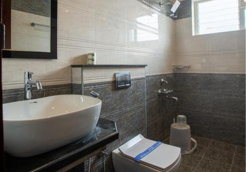 a bathroom with a sink and a toilet at PARKKAVAN TOWERS in Tiruchchirāppalli