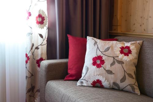 a couch with two pillows on it next to a window at Hotel Auhof in Grossarl