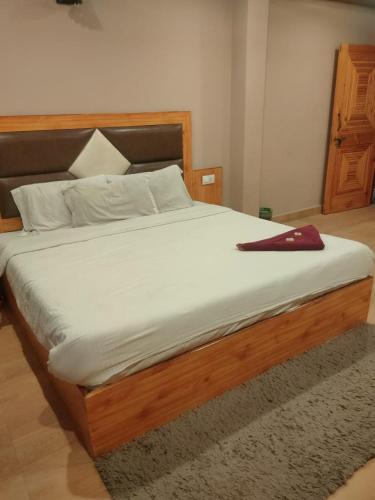 a bedroom with a bed with a red purse on it at hotel inn in Manāli