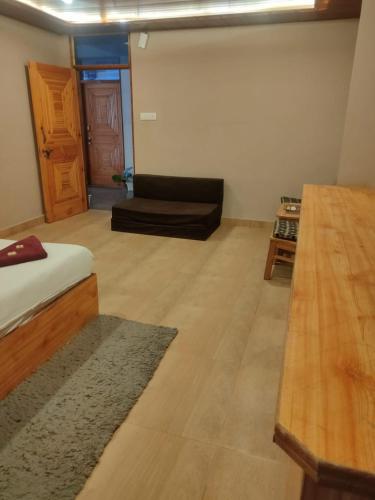 uma sala de estar com um sofá e um piso de madeira em hotel inn em Manali