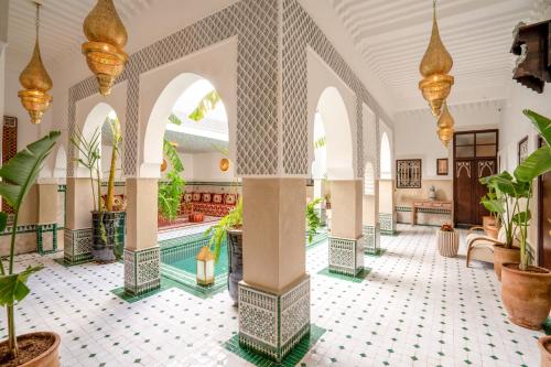 - un hall avec une piscine au milieu d'un bâtiment dans l'établissement BÔ Riad Boutique Hotel & Spa, à Marrakech
