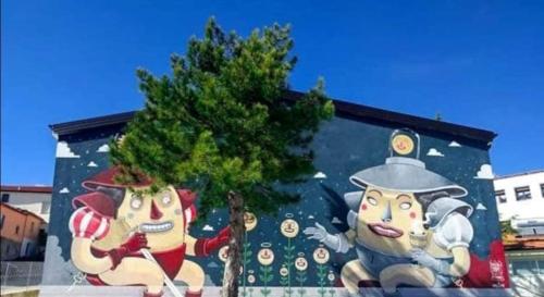 un murale su un edificio con un albero di fronte di Casa panoramica 