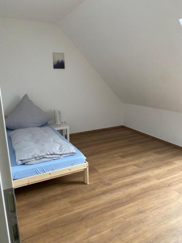 a bedroom with a bed and a wooden floor at Ferienwohnung Landhege in Michelfeld