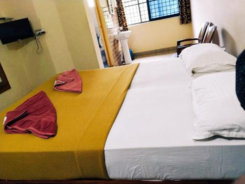 a large bed with two towels on top of it at Hotel Varsha Hampi in Hampi