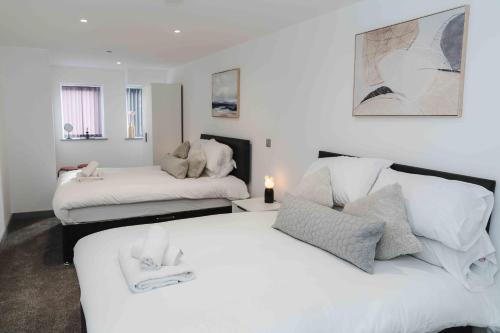 a bedroom with two beds with white sheets at Stunning Luxury Stay by VICHY in Hull