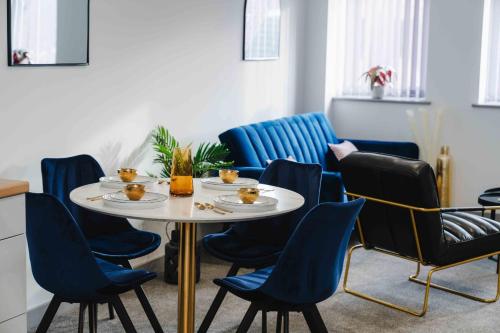 a table and chairs in a room with blue chairs at Stunning Luxury Stay by VICHY in Hull