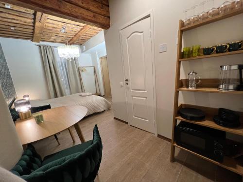 a small living room with a table and a bedroom at Karlova Manor Apartments in Tartu
