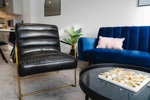 a living room with a leather chair and a blue couch at Stunning Luxury Stay by VICHY in Hull