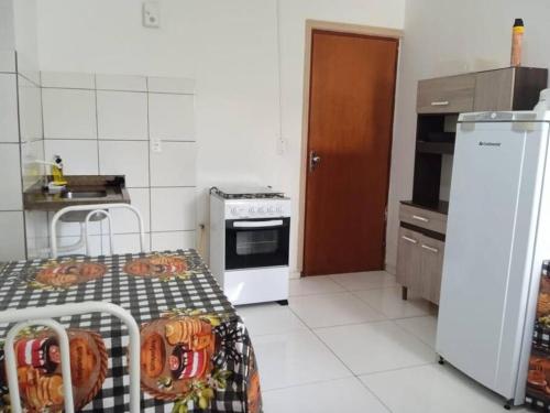 Il comprend une petite cuisine équipée d'une cuisinière et d'un réfrigérateur. dans l'établissement Refúgio Termal: Seu Paraíso em Caldas novas, à Caldas Novas