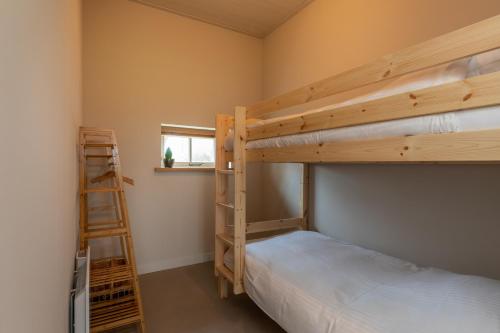 a bedroom with two bunk beds and a ladder at Vakantiewoning - Pioniersweg 3 - Grijpskerke 'De kleine Pionier' in Grijpskerke