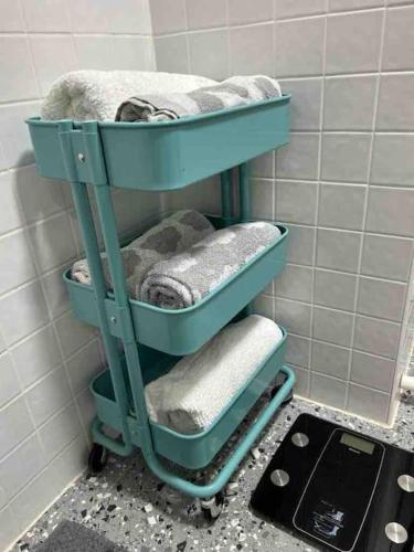 a blue shelf with towels on it in a bathroom at “Urban Oasis ” Central emporium apt ,Free Parking in Melbourne