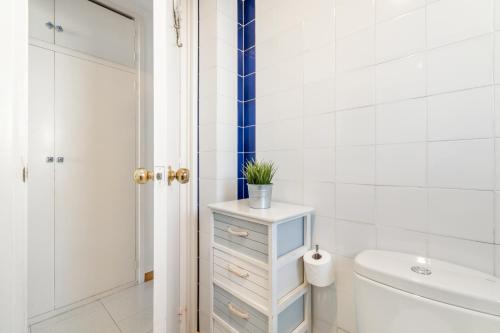 a bathroom with a white toilet and a sink at Romantic: Precioso frente al mar in Sitges