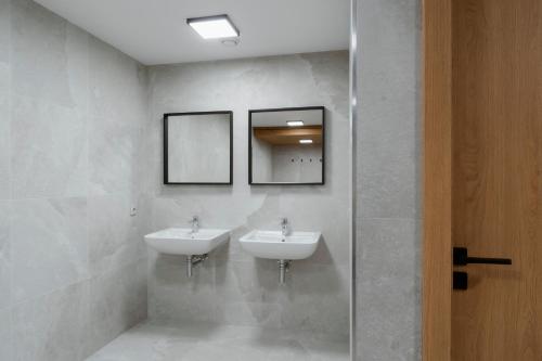 a bathroom with two sinks and two mirrors at Mlýn Herlíkovice in Hořejší Vrchlabí
