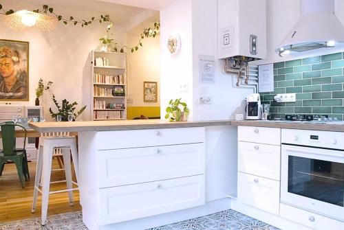 a kitchen with white cabinets and a table in it at Chez Frida - Sublime appartement - Centre Voiron in Voiron