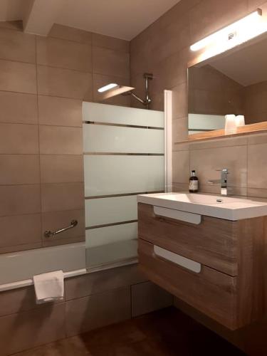 une salle de bain avec un lavabo, un miroir et une baignoire dans l'établissement Bon-Séjour, à Thollon-les-Mémises