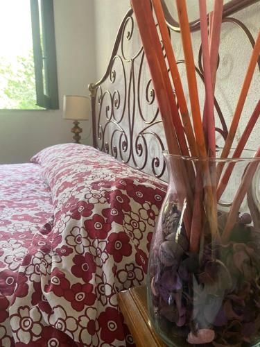 Villa Kenia Flora في ماراتييا: وجود مزهرية على طاولة بجانب سرير