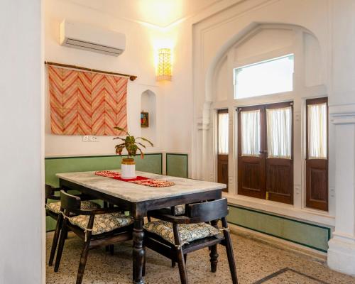 a dining room with a table and chairs at Sum Jaipur in Jaipur