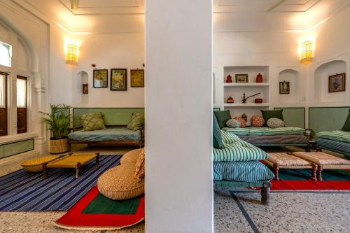a living room with couches and tables in a room at Sum Jaipur in Jaipur