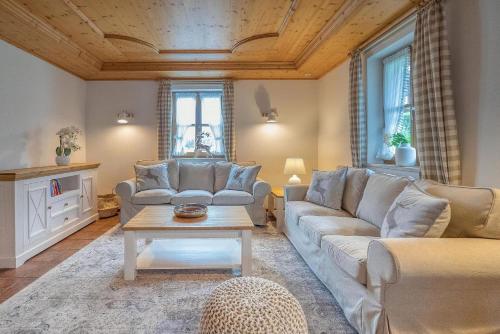 ein Wohnzimmer mit einem Sofa und einem Tisch in der Unterkunft Landhaus Königssee in Schönau am Königssee