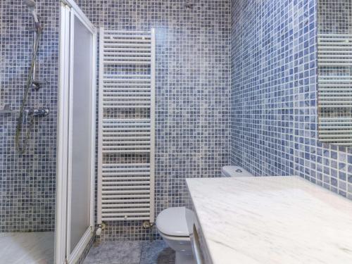 een badkamer met een toilet en een douche met blauwe tegels bij Apartamento Llançà, 2 dormitorios, 6 personas - ES-228-14 in Llança