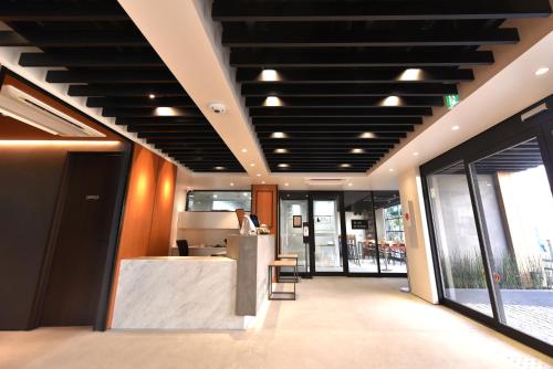 a lobby with a counter in a building with windows at ホテルプラタナス新横浜 in Yokohama