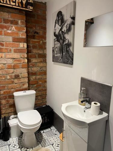 bagno con servizi igienici bianchi e lavandino di East Bridgford Coach House Inc Spa and Treatments a East Bridgford