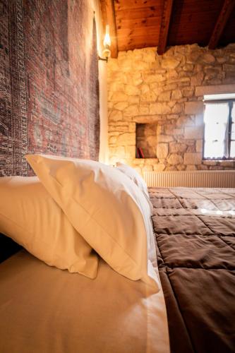 a bedroom with a large bed with a stone wall at Guesthouse Armakas in Kalavrita