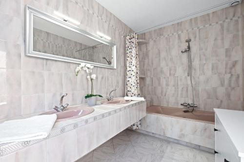 ein Badezimmer mit zwei Waschbecken und einer Badewanne in der Unterkunft Villa Baladou in Fréjus