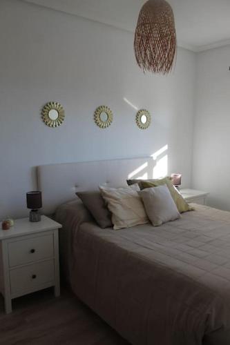 - une chambre avec un lit et 2 réveils sur le mur dans l'établissement Apartamento en Los Arenales, à Alicante
