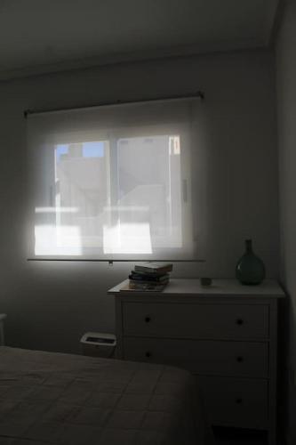 - une chambre avec une fenêtre, une commode et un lit dans l'établissement Apartamento en Los Arenales, à Alicante