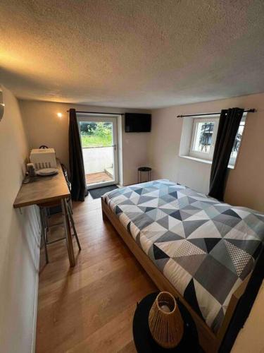 a bedroom with a bed and a desk and a window at studio avec jardin et stationnements in Bourges