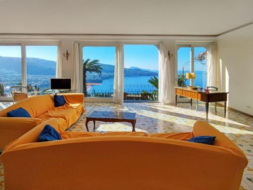 una sala de estar con muebles de color naranja y vistas al océano. en Giardino 21 Marzo, en Vico Equense