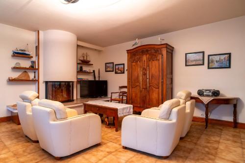a living room with white chairs and a table at Langlazic - Maison 3 chambres avec jardin in Clohars-Carnoët