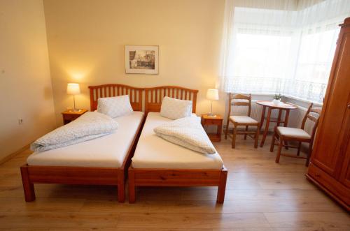 1 dormitorio con 1 cama, mesa y sillas en Gästehaus Mariola, en Wulkaprodersdorf