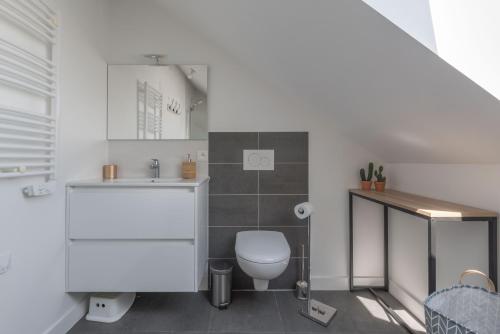 a bathroom with a toilet and a sink at L'Escampette - A 650m de la plage in Saint-Nazaire