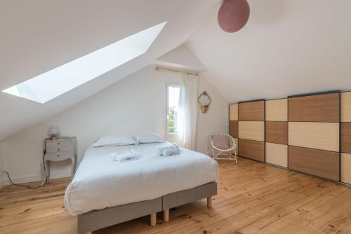 Un dormitorio blanco con una cama y una ventana. en L'Escampette - A 650m de la plage, en Saint-Nazaire